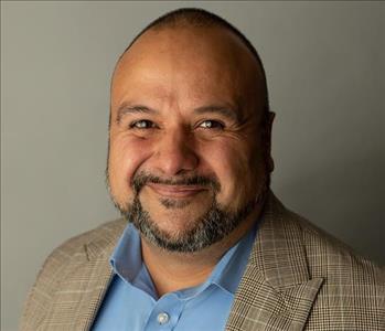 Man in brown coat and blue shirt