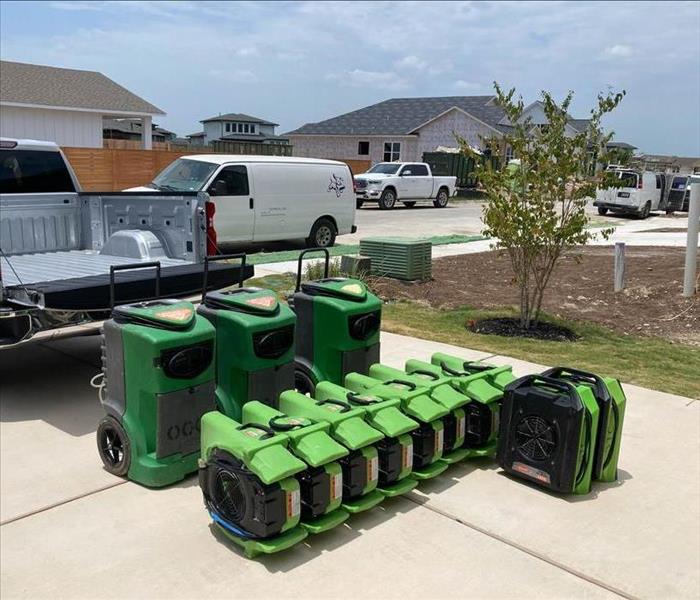 Drying equipment being unloaded on driveway.