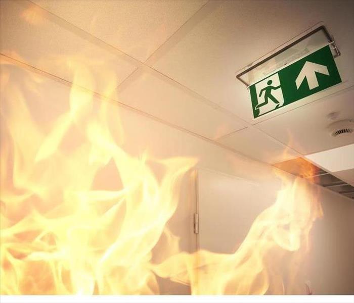 Fire burning and an exit sign on the ceiling.