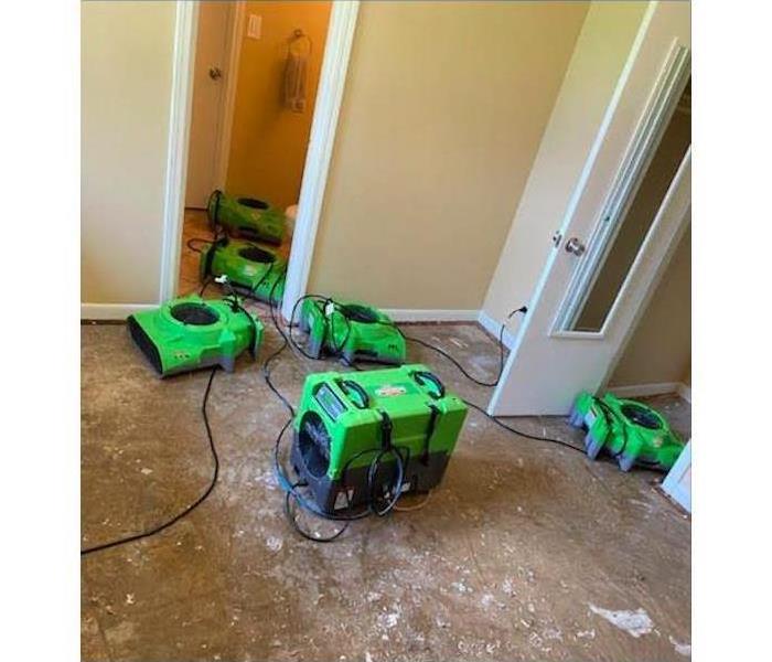 air movers placed on bathroom and bedroom, floor has been removed. Concept of water damage
