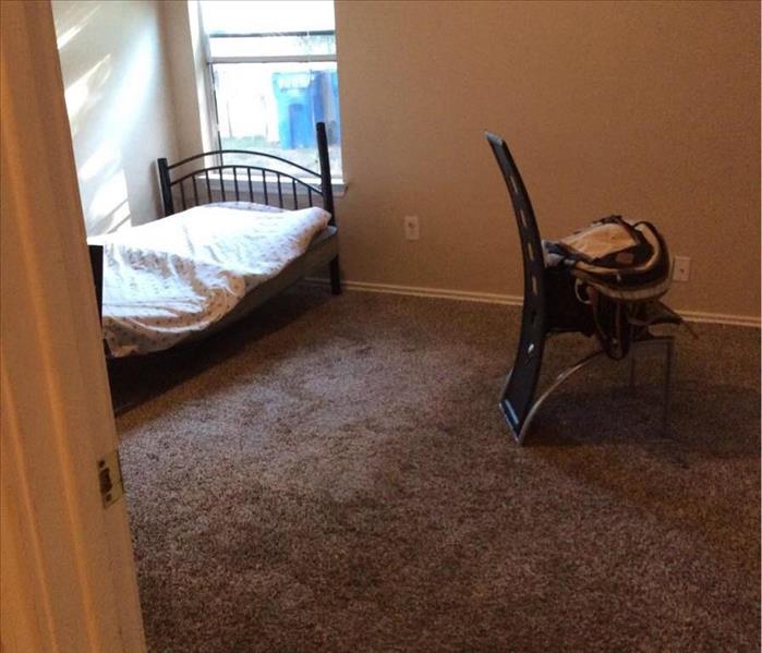Bedroom with water damaged carpet.
